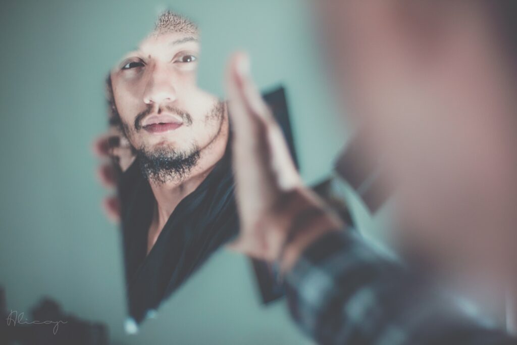 Image of man looking into broken mirror