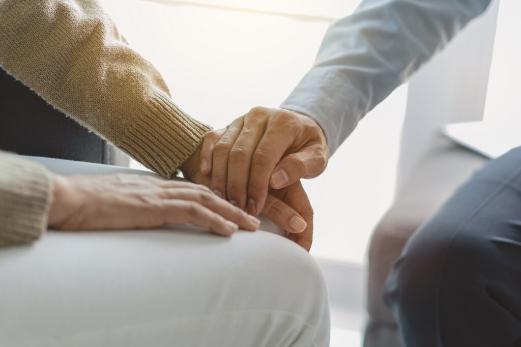 Image of man offering encouraging touch to another