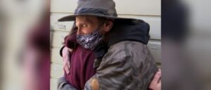 Image of tween girl hugging a homeless man