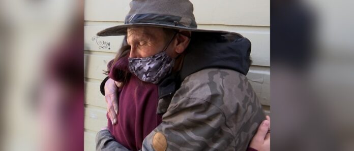 Image of tween girl hugging a homeless man
