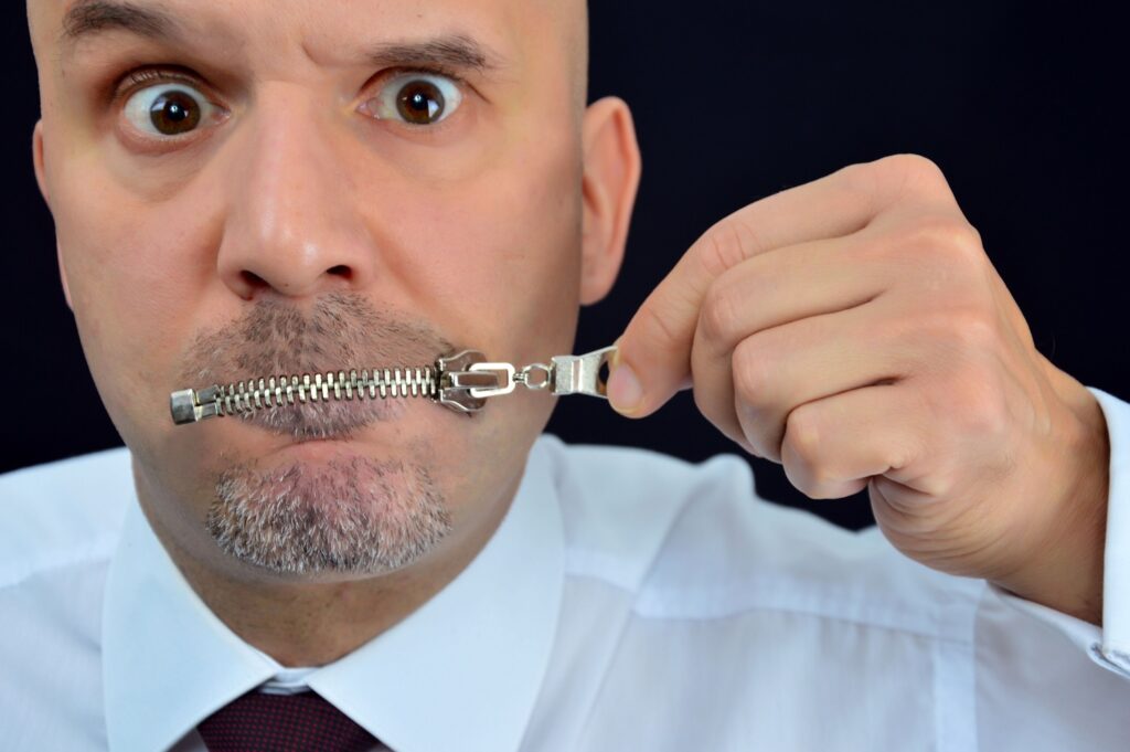 Image of man zipping his mouth shut