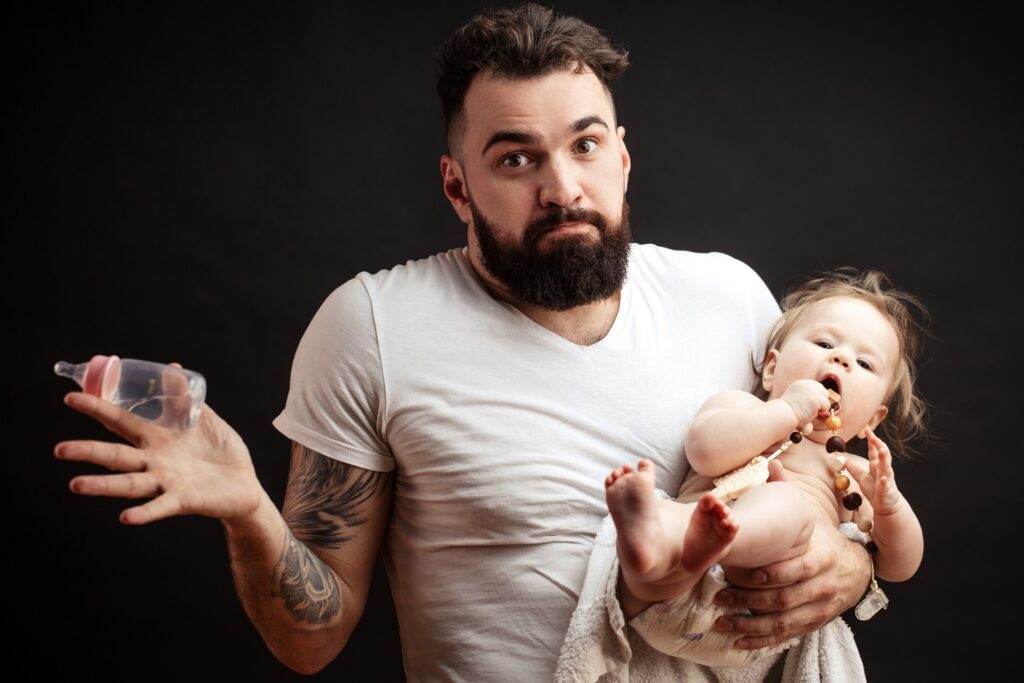 Picture of confused man trying to feed a baby