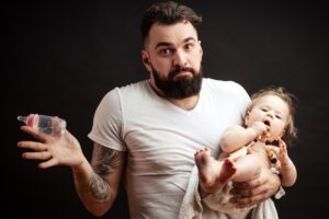 Picture of confused man trying to feed a baby